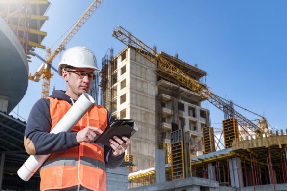 A construction worker looks at plans on his tablet