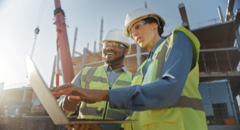 construction workers discussing project plans at a busy worksite
