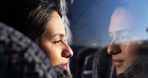 passenger looks out the window of a bus